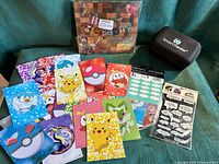 Overview of all items: Pokémon cards, Minecraft kit, VR headset, photo props