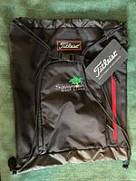Full view of backpack front showing Titleist logo, Savannah Golf Links embroidery, red-zip pocket, hang tag
