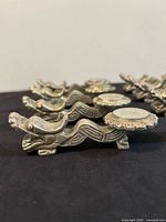 Side view line-up of dragon rests showing design and patina