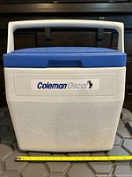 Front view showing Coleman Oscar logo, lid, handle