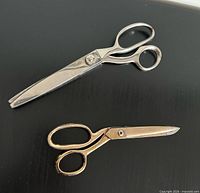Both shears displayed closed on black surface