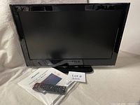 Front view of Hisense 24" LCD TV with remote and manual