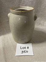 Front view of glazed stoneware crock jar with lot tag