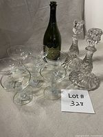 Group view: seven champagne coupes, two swirled candlesticks, one Dom Pérignon bottle