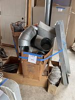 Gaylord box with multiple galvanized elbows, collars, rectangular duct pieces and stack of flexible duct