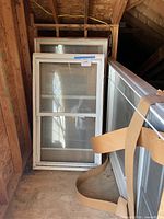 Stacked white vinyl windows including large picture window and smaller double-hung units