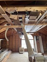 Overhead rafter shelf holding mixed boards and curved trim pieces
