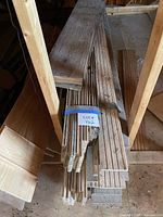 stack of narrow oak flooring strips and wider boards