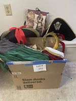 Box showing multiple costumes, pirate hats, crown, packaged pirate costume