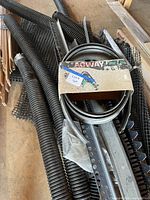 Corrugated pipes, plastic mesh, perforated rails, grey edging coil visible