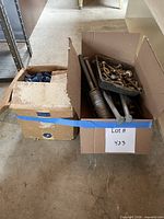 Two open boxes showing assorted metal fasteners and plastic anchors