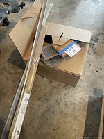 Box containing cable coil, floor registers, packaged and loose transition strips