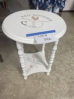 Top view of white round side table showing coffee stencil and turned legs