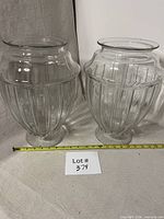 Front view of both clear glass urn vases with measuring tape for scale