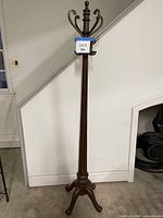Full view of wooden coat rack with tripod base