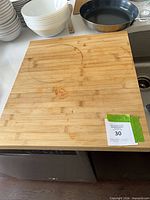 Top view of bamboo cutting board on counter, showing size, juice groove, and stains