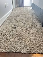 Full view of rug length beside bed showing high pile texture