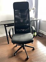 Front view of black IKEA MARKUS office chair showing mesh back, seat, armrests and wheeled base