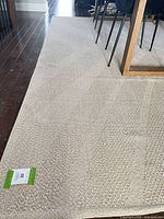 Full view of cream low pile rug under dining table