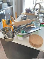 Main grouping of utensils in bowl, utensil holder, cork trivets