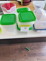 Stack of square green-lidded containers, rectangular containers with blue lids