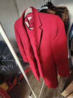 Front view of red Anne Klein blazer on hanger with matching dress beneath