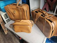 All three brown leather travel bags together
