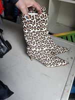 Side view of both boots showing leopard print, heel height and overall style