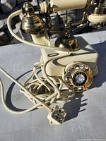 Telephone front showing rotary dial, brass fittings and cords