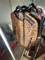 Two leopard print sweatshirts on hangers