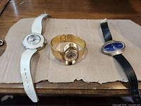 Front view of three watches side by side on cardboard