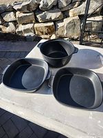 All three black stoneware bakeware pieces on table