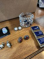All jewelry pieces arranged on table: two bracelets, four earring pairs, one ring