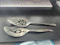 Top view of both spoons showing bowl piercings and tarnish