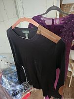 Front view of black sweater with shoulder zipper and elbow patch visible