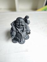 Front view of charcoal resin Laughing Buddha figurine showing beads, staff, missing crystal ball hand