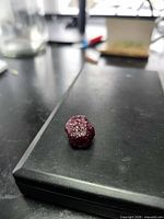 Front angled view of rough ruby stone on black surface