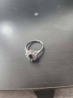 Top view of ring displaying blue center stone and halo of clear accents