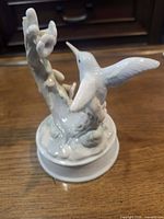 Front left view of porcelain hummingbird and flowers on round base