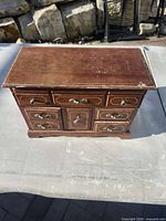 Closed brown wooden jewellery box showing exterior condition