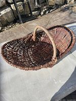 Full view of oval wicker harvest basket with handle