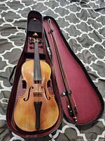 Violin in opened shaped case with bow
