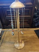 Full view of wood necklace stand with hanging necklaces