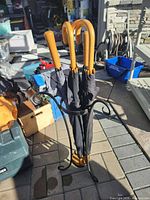 Overall view of umbrella stand holding three umbrellas