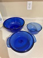 Overview of all three cobalt blue glass pieces: casserole with lid, mixing bowl, large pasta bowl