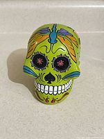 Front view of green resin sugar skull coin bank