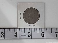 Obverse of 1969 UK 50p coin in flip with ruler for scale