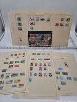 Overview of album pages and loose stock card with assorted Indonesian stamps
