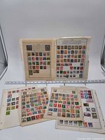 Group view of all six stamp album pages with ruler for scale