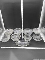 Group shot of all ten pressed glass bowls with rulers for scale